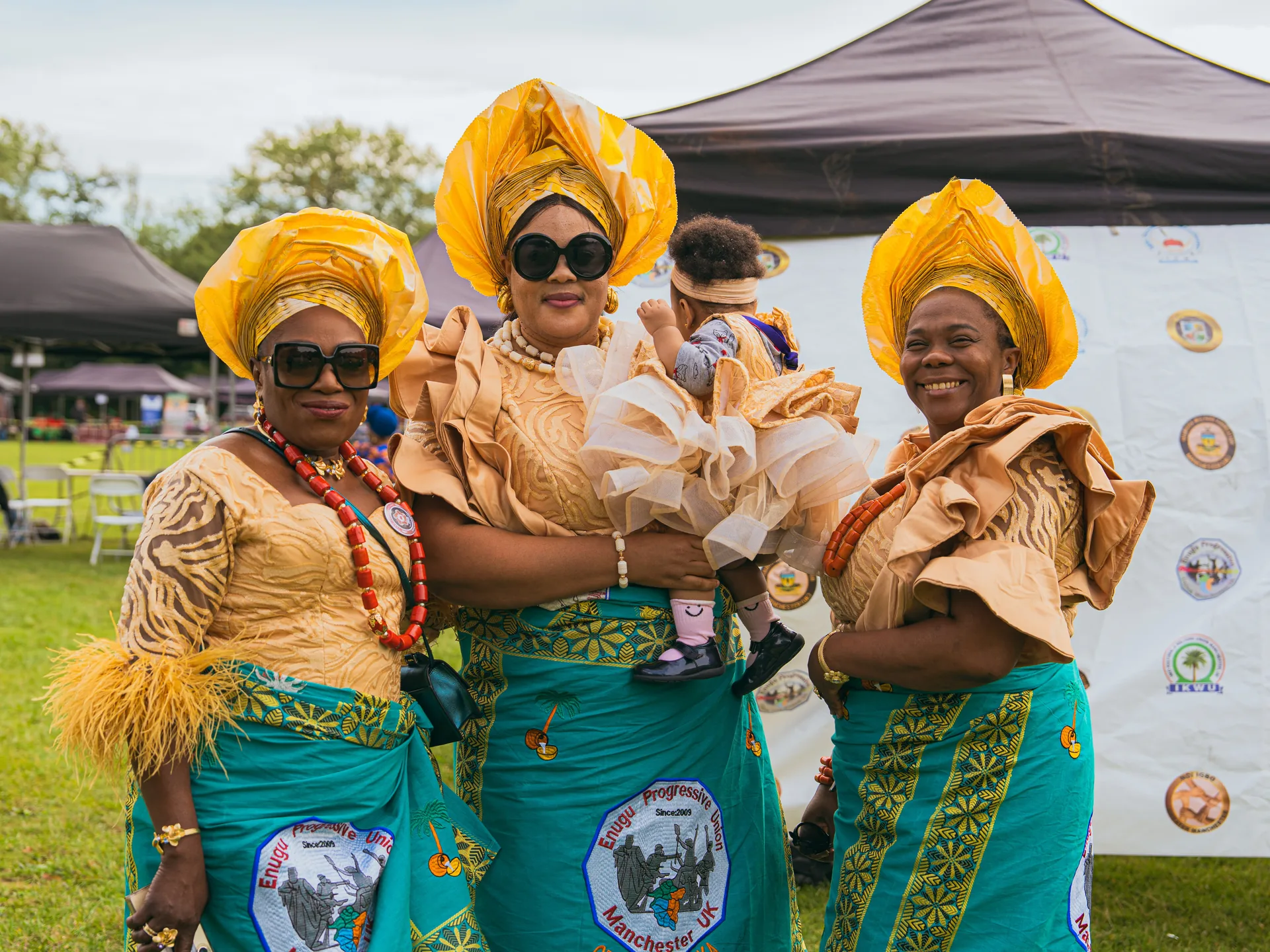 Women in yellow gele with a baby