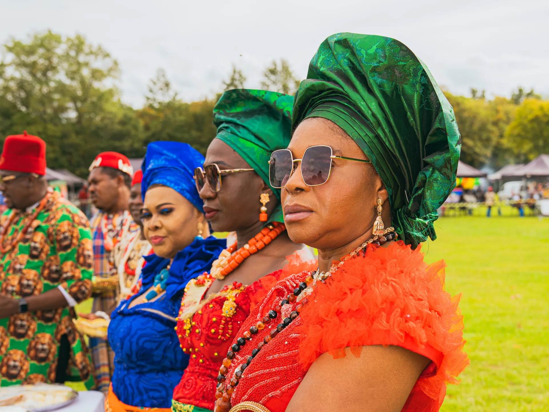 Row of guests in green gele watching the ceremony